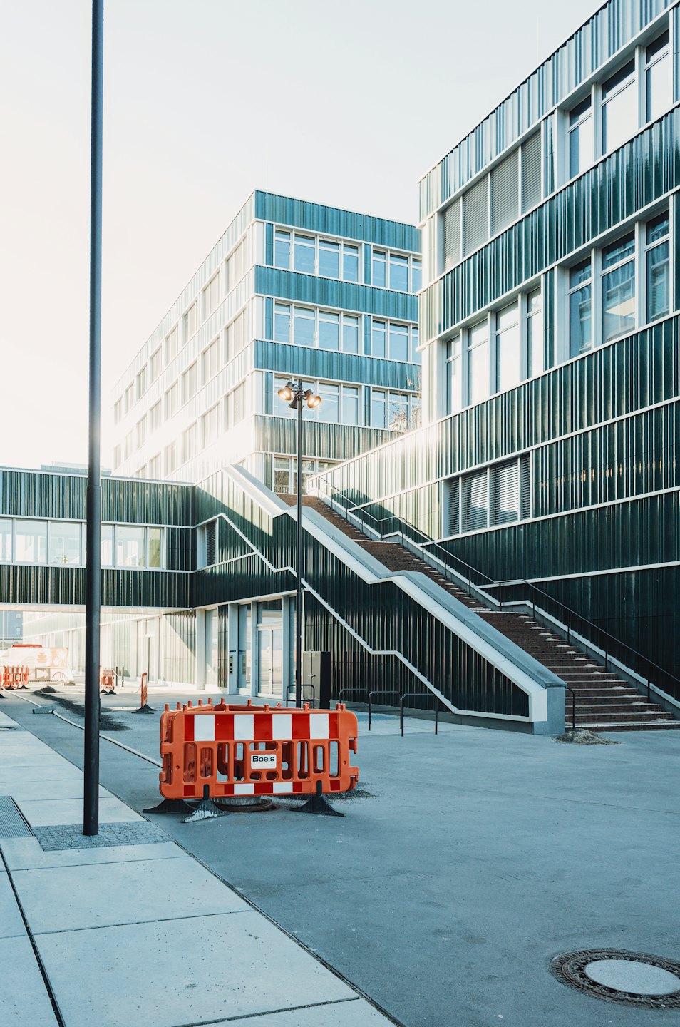 Modern corporate campus with striped buildings and outdoor staircase.